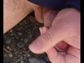 Gay Japanese man pleasuring himself outdoors by the sea.